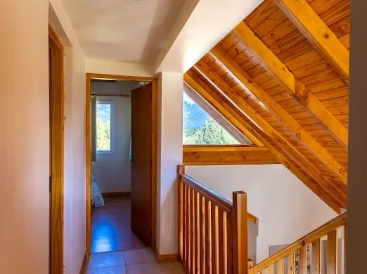 Cabaña de madera amarilla con deck en Villa Los Coihues, Bariloche