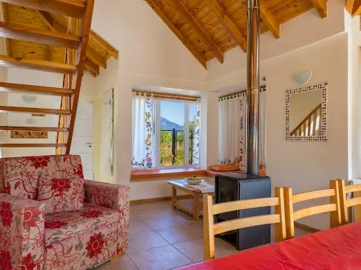 Dormitorio con vista a la montaña y al bosque en cabaña de Villa Los Coihues, Bariloche