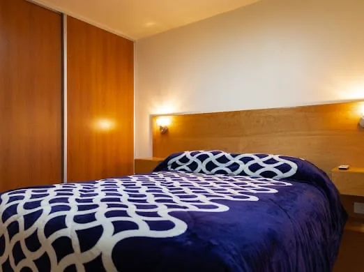 Dormitorio con TV y edredón azul en la cabaña de Bariloche