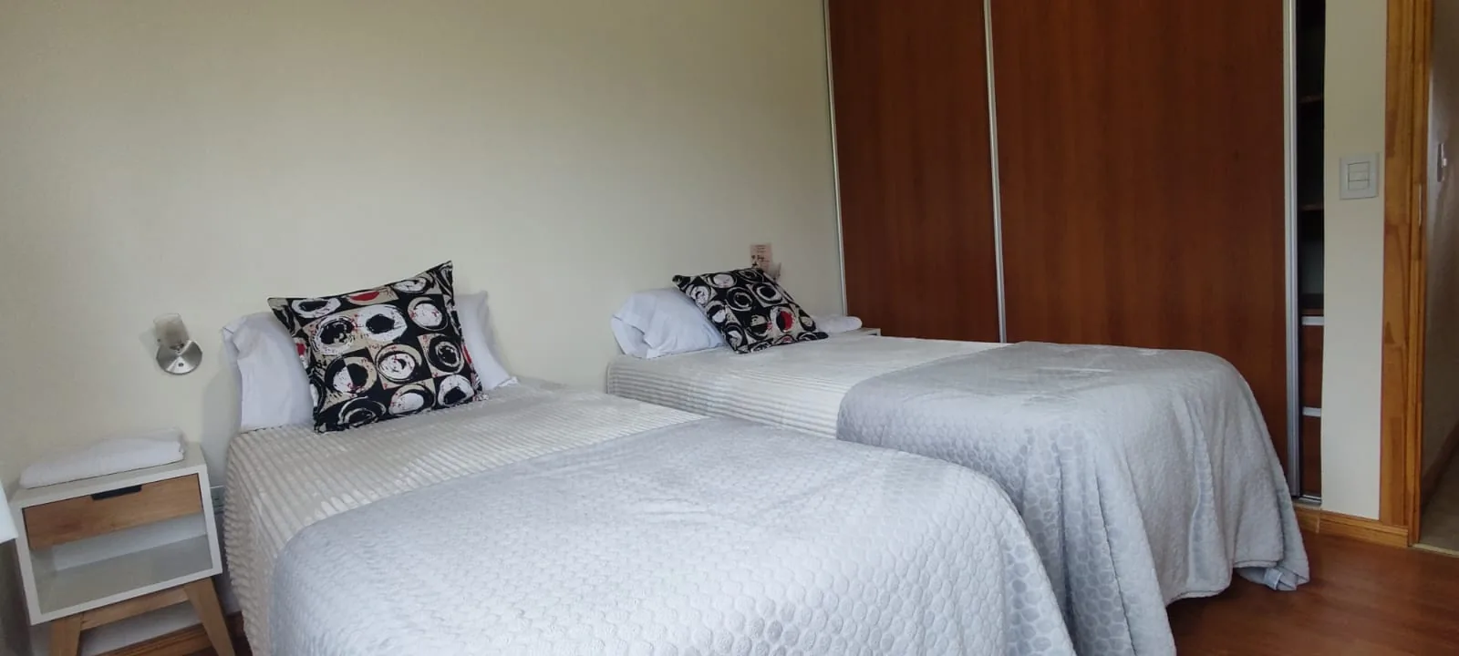 Dormitorio en planta alta con dos camas individuales y placard amplio en la cabaña de Bariloche